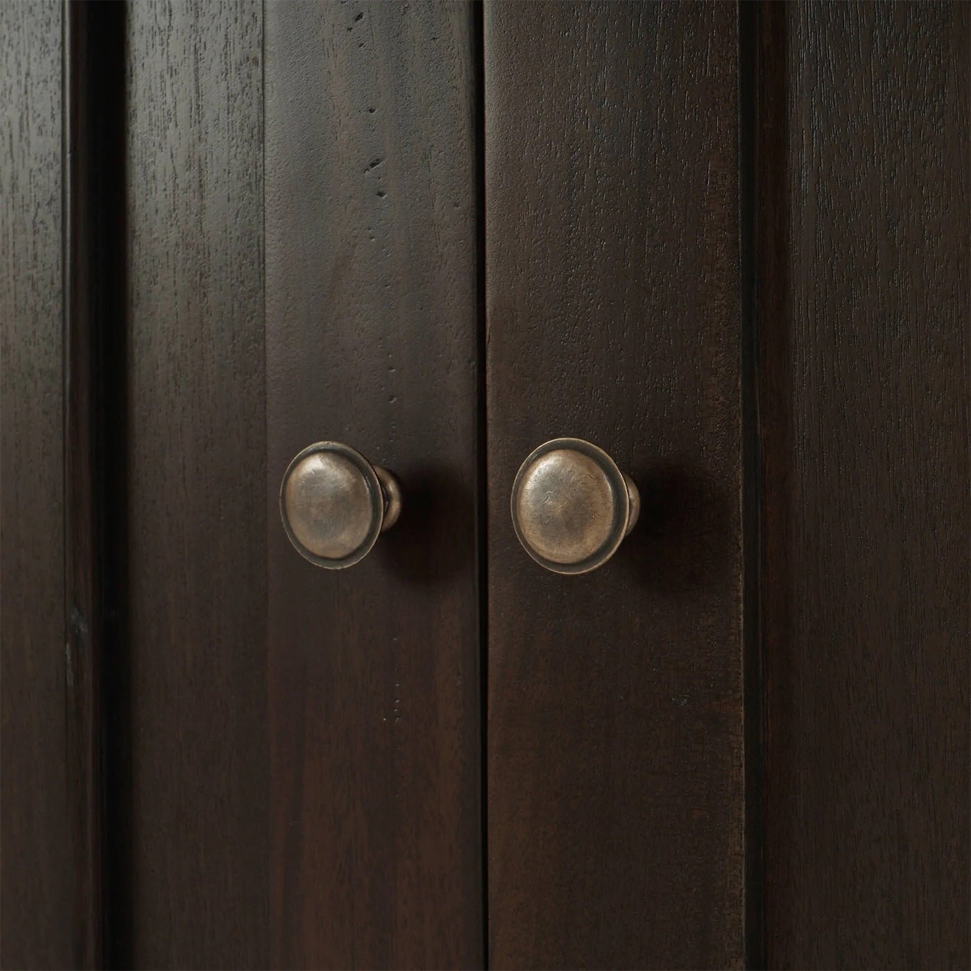 Cabinet door knobs close-up, rustic design, walnut finish.
