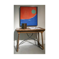 Console table styled with decor, artwork above, indoor setting.