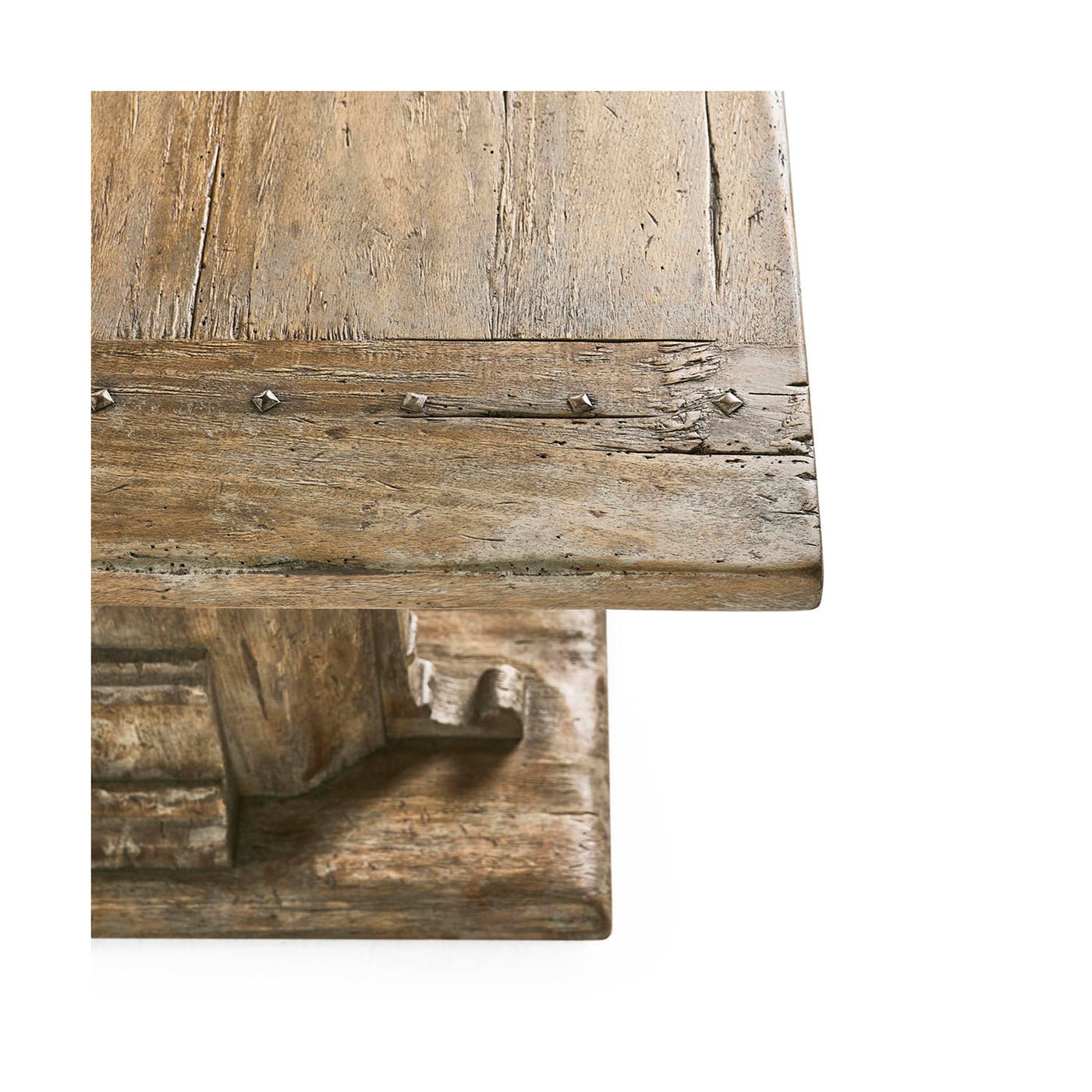 Rustic coffee table corner with nailhead accents close-up.