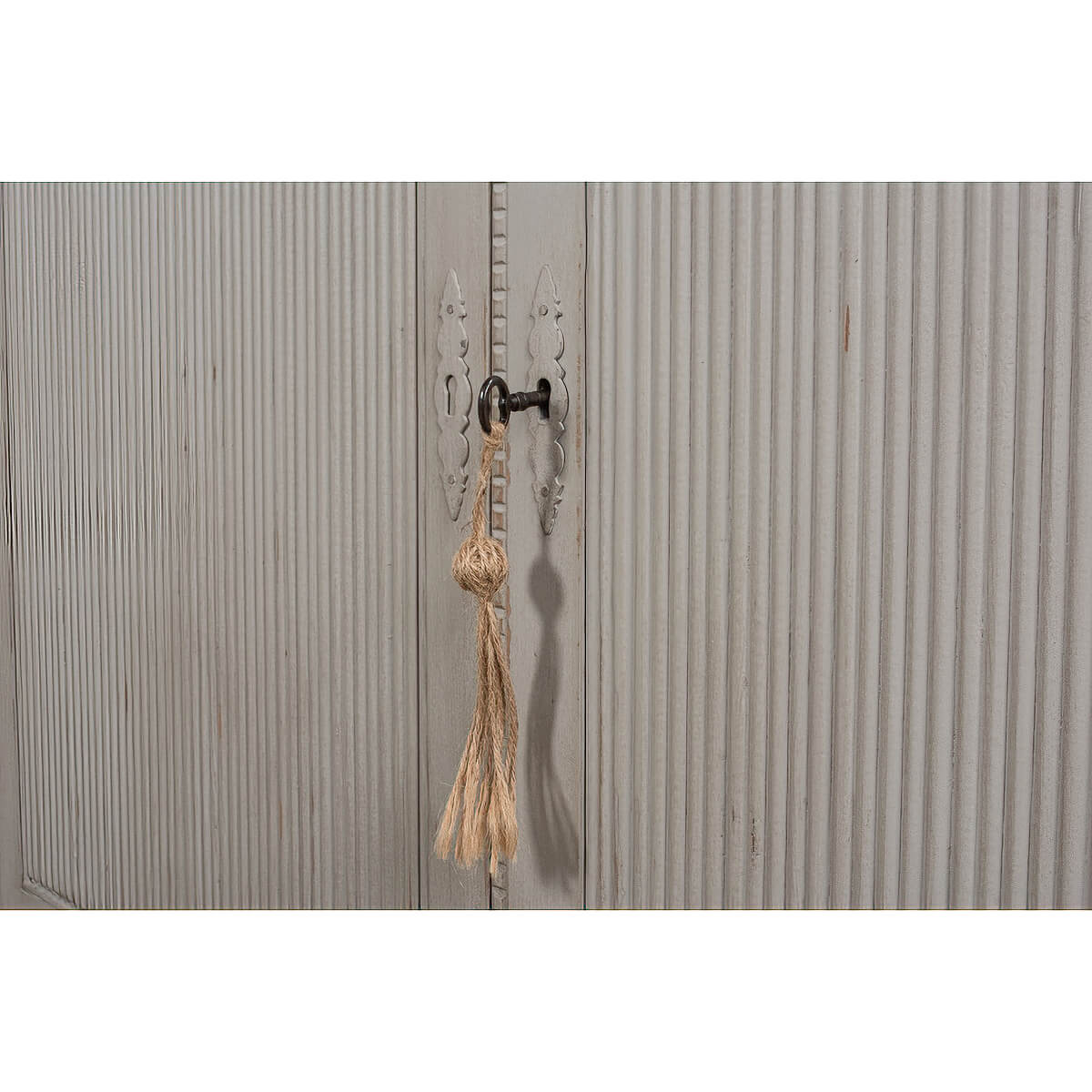 Close-up of latch on rustic grey painted bookcase lower door