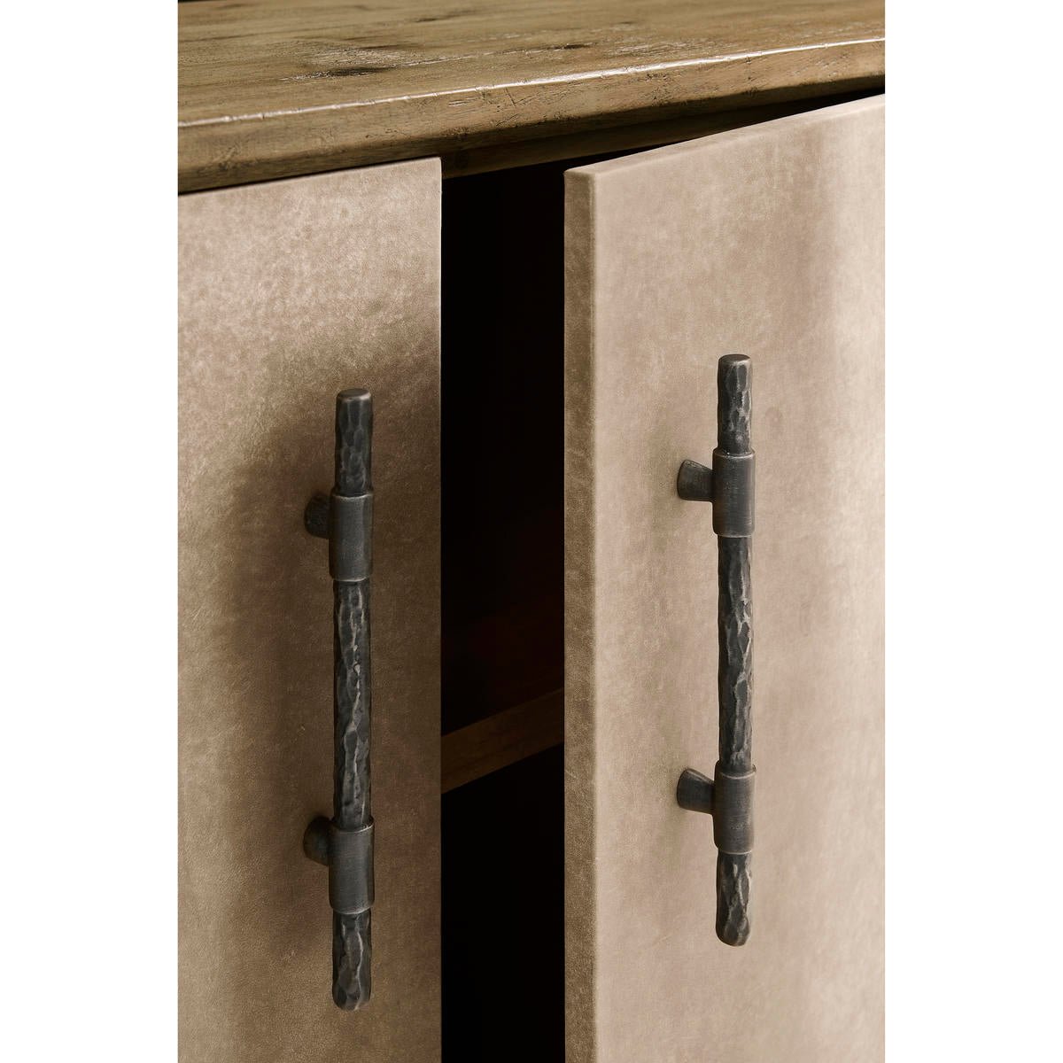 Close-up of open doors on rustic leather credenza.