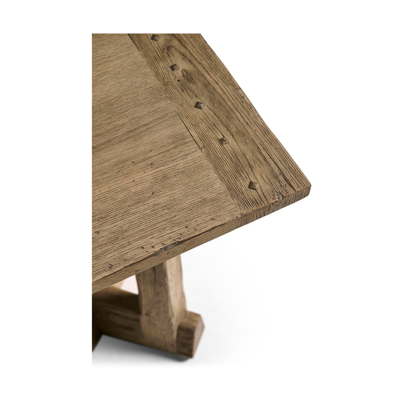Textured surface corner of rustic table with nail details.
