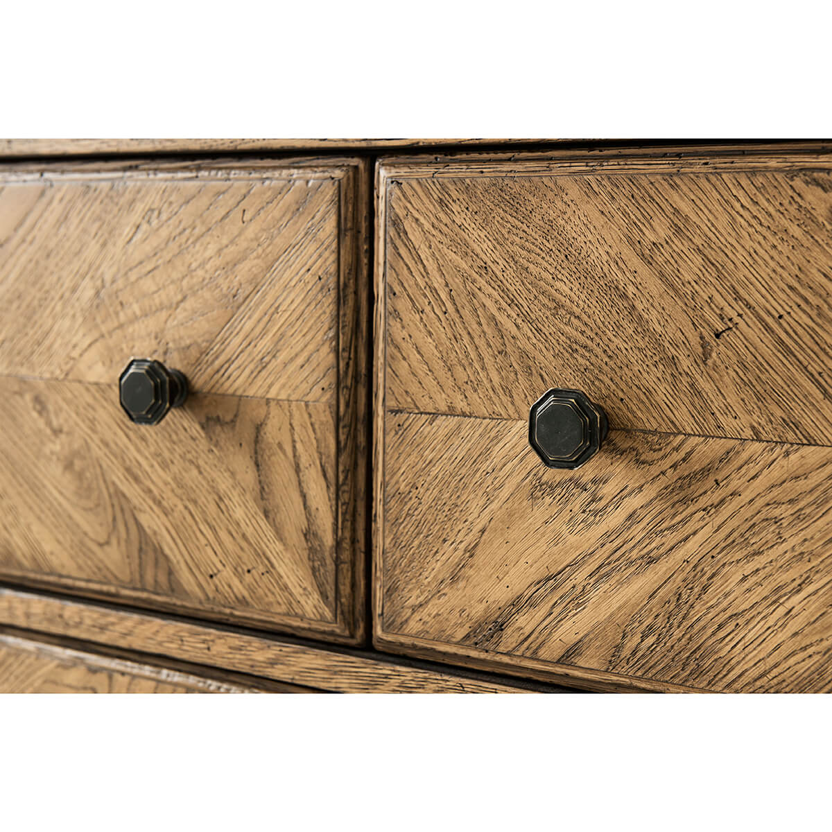 Close-up of dresser drawer knobs, oak parquetry texture.