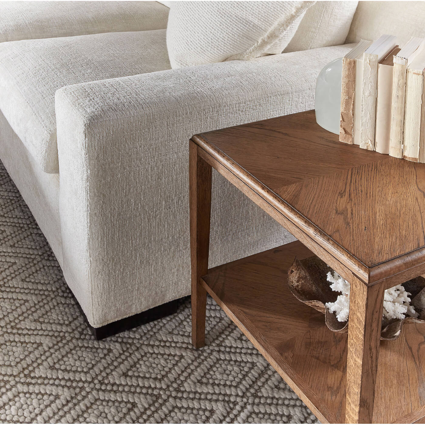 Side table next to cream sofa with books.