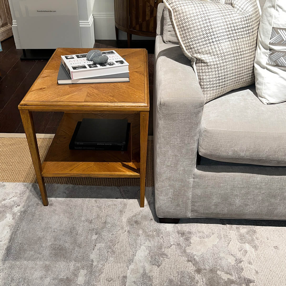 Rustic oak side table beside gray sofa.