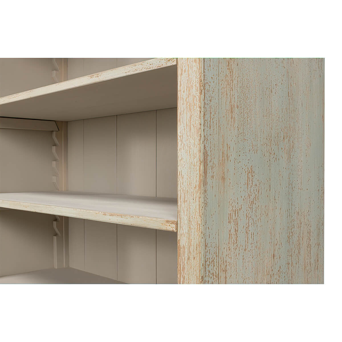 Shelf detail on rustic painted bookcase with distressed finish.