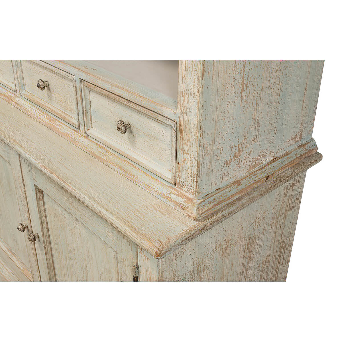 Corner detail of rustic painted bookcase top and drawers.