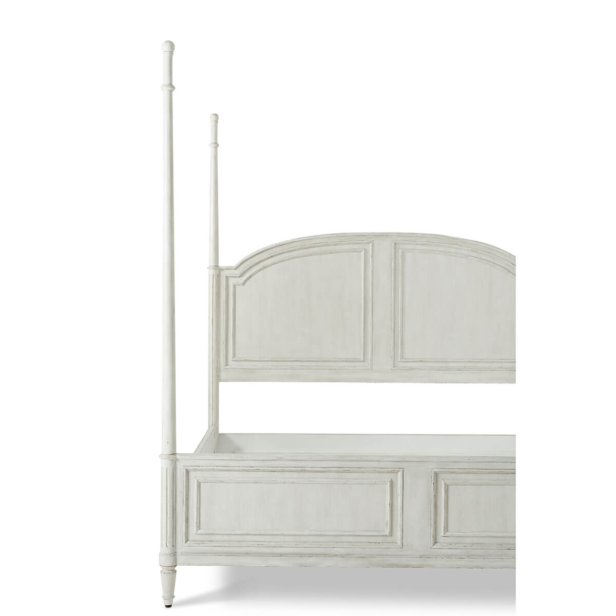 Partial view of rustic bed with tall posts, no bedding.