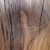Close-up of the reclaimed wood bench surface showing dark grain, knots and long natural splits