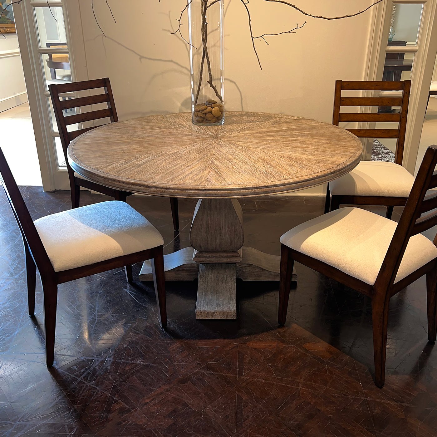 Round dining table with four chairs around it.