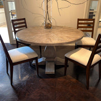 Round dining table with four chairs around it.