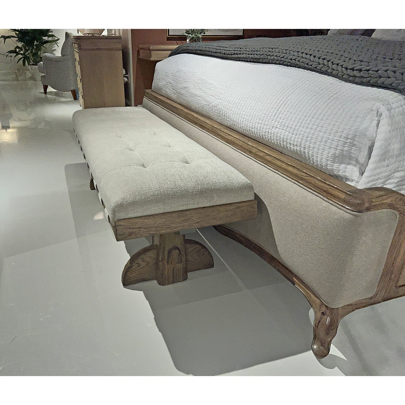 Side view of rustic trestle bench by bed.