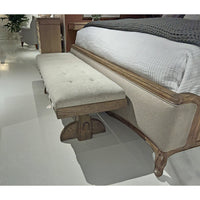 Side view of rustic trestle bench by bed.