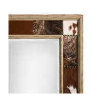 Detailed corner view of rustic mirror's cowhide inlay.