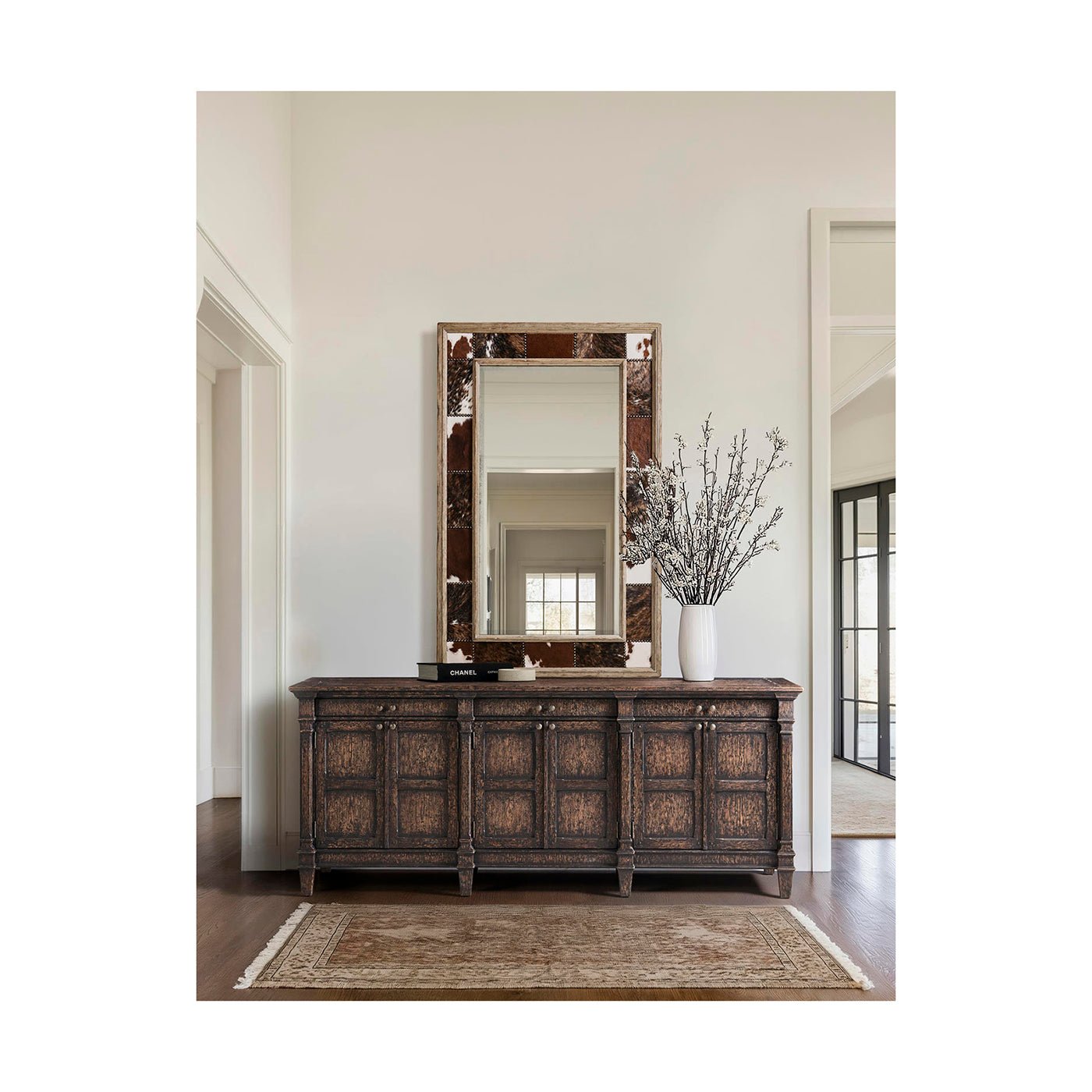 Rustic mirror over dark wooden cabinet in living space.