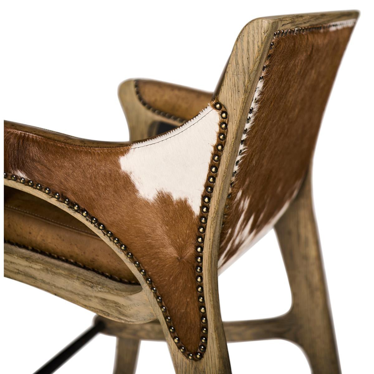 Close-up Rustic Western bar stool, cowhide and stud accents.