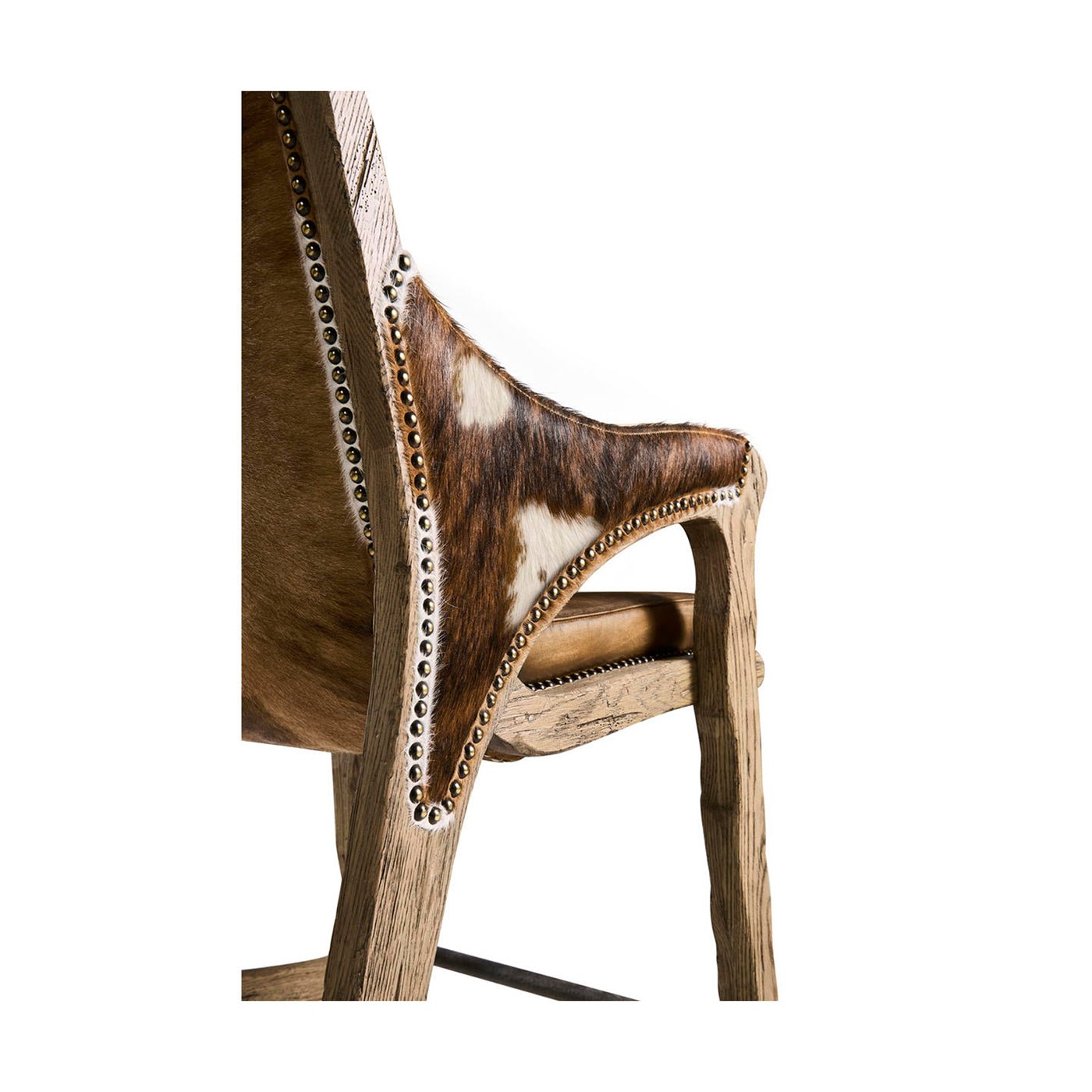 Close-up of hide upholstery and studs on rustic stool.