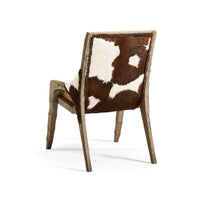 Rustic western chair back showing cowhide upholstery detail.