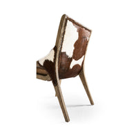 Rustic chair back curve showing cowhide and wood frame.