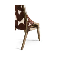Rustic chair side view showing cowhide and frame design.