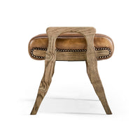 Rustic footstool side profile, wooden legs and leather seat.