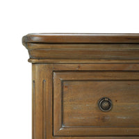Close-up of corner on rustic wood chest of drawers.