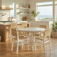 Dining room featuring white chairs with a round table.
