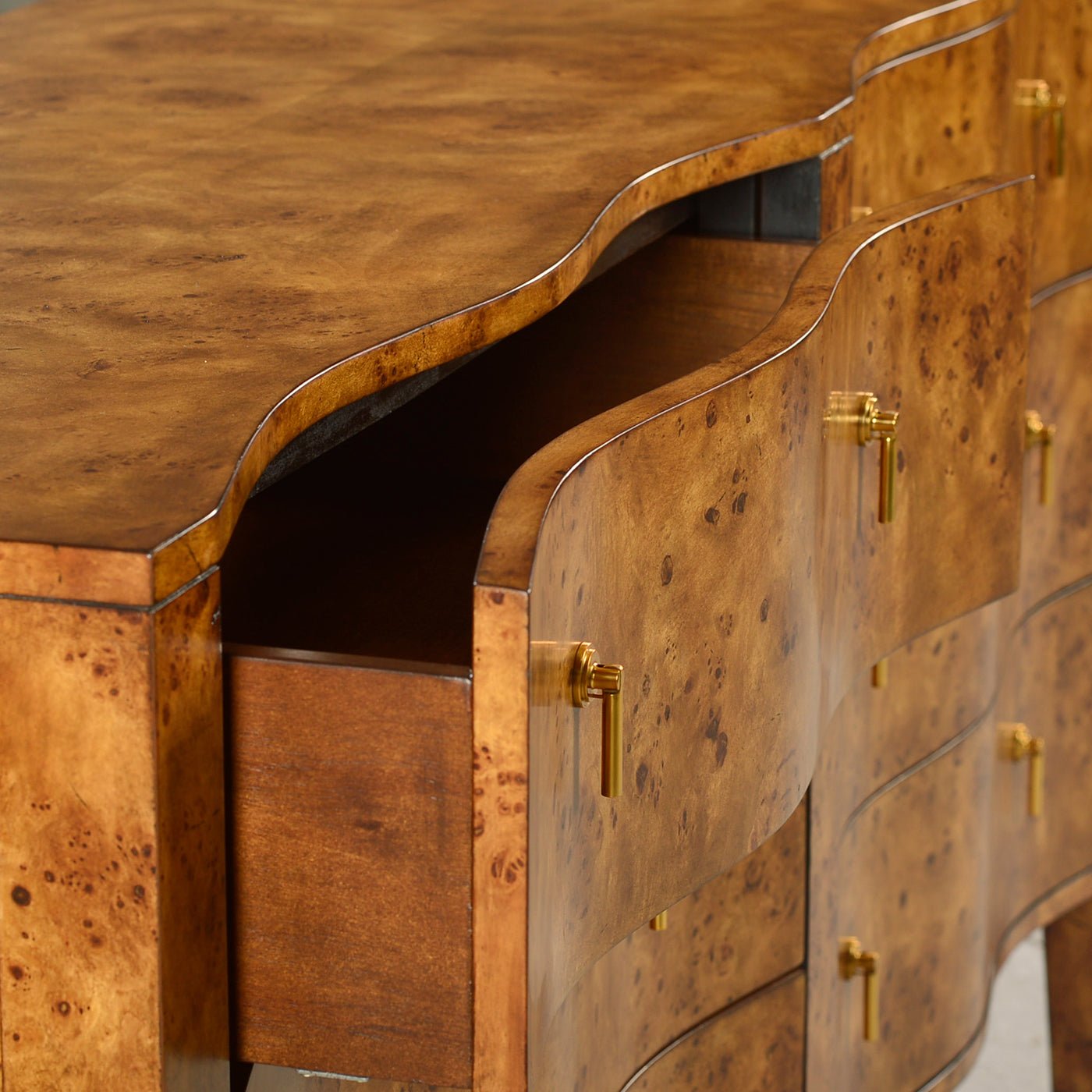 Upper drawers open on serpentine burl wood dresser.