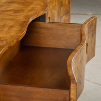 Inner view of drawer in serpentine burl wood dresser.