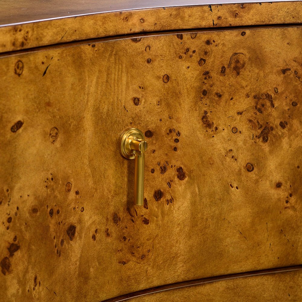 Close-up handle on serpentine burl wood dresser.