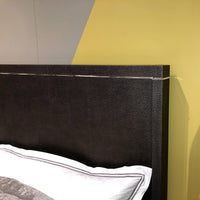 Headboard detail against a geometric wall background.