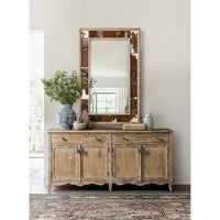 Sideboard in room with mirror and decorations.