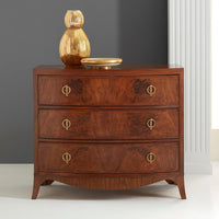 Styled walnut chest of drawers with decorative items on top.