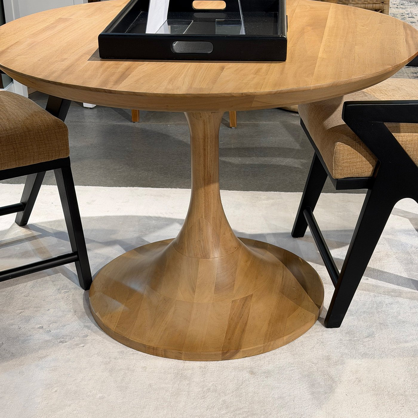 Tulip dining table with black chairs, close-up view.