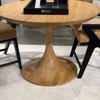 Tulip dining table with black chairs, close-up view.