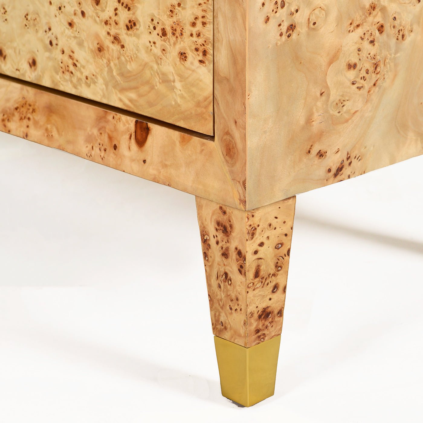 Burl cabinet leg with brass accent close-up.