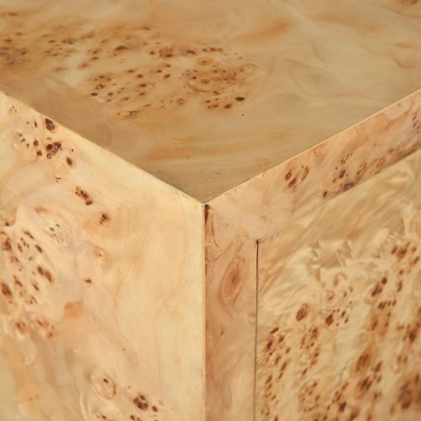 Close-up of light burl cabinet corner.