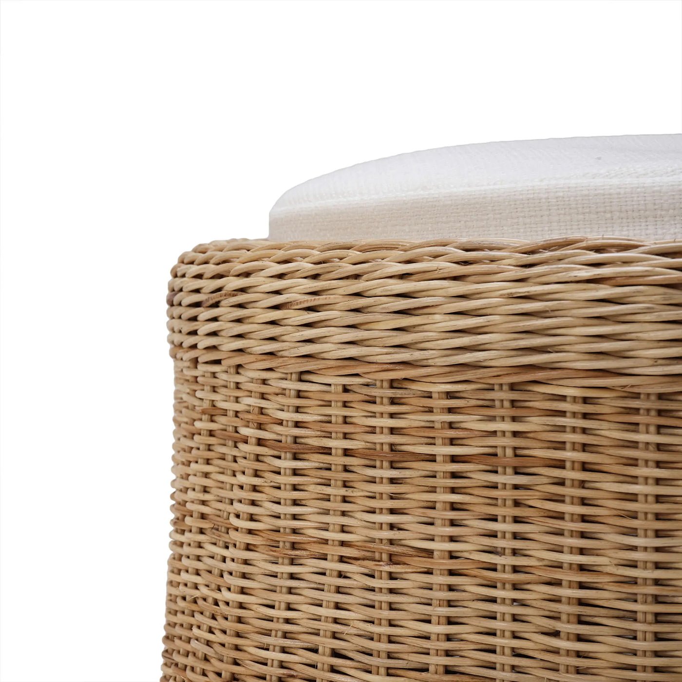 Close-up of rattan ottoman texture and cushion detail.