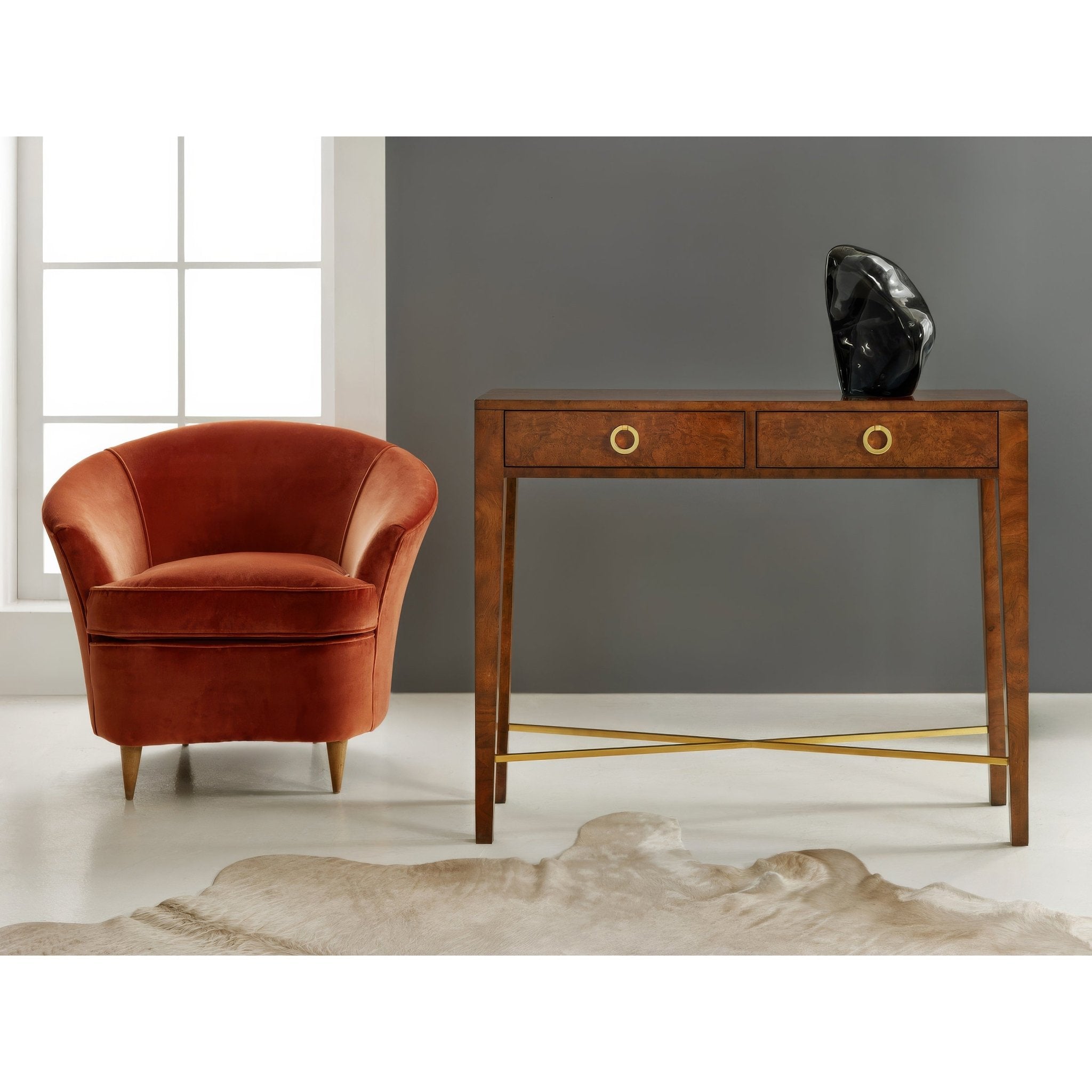 Console table with chair and sculpture in room setting