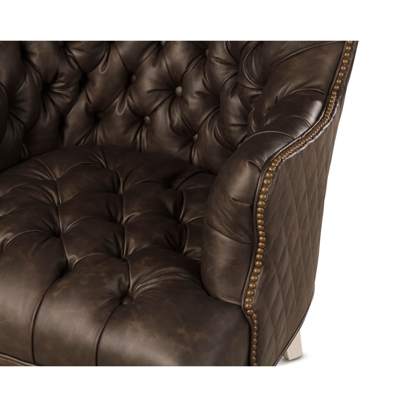 Close-up of tufted leather detail, accent chair armrest.