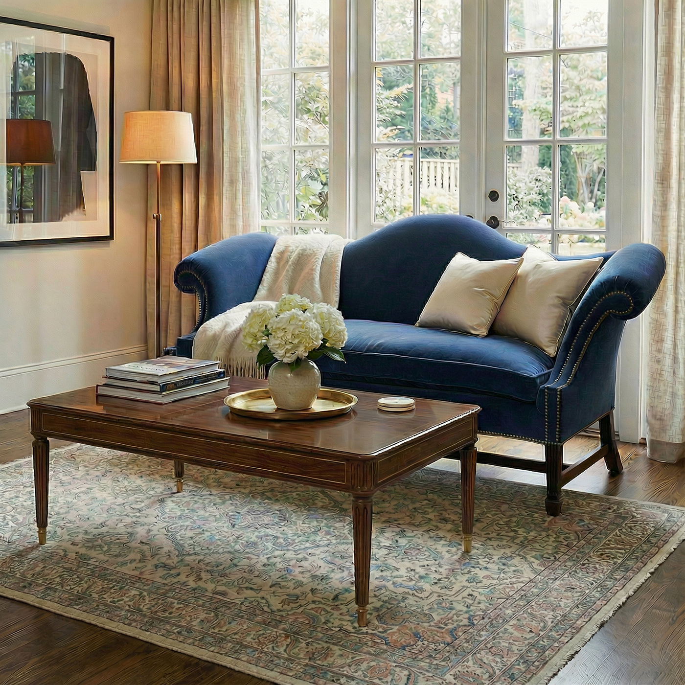 Blue camelback sofa in cozy living room setting.
