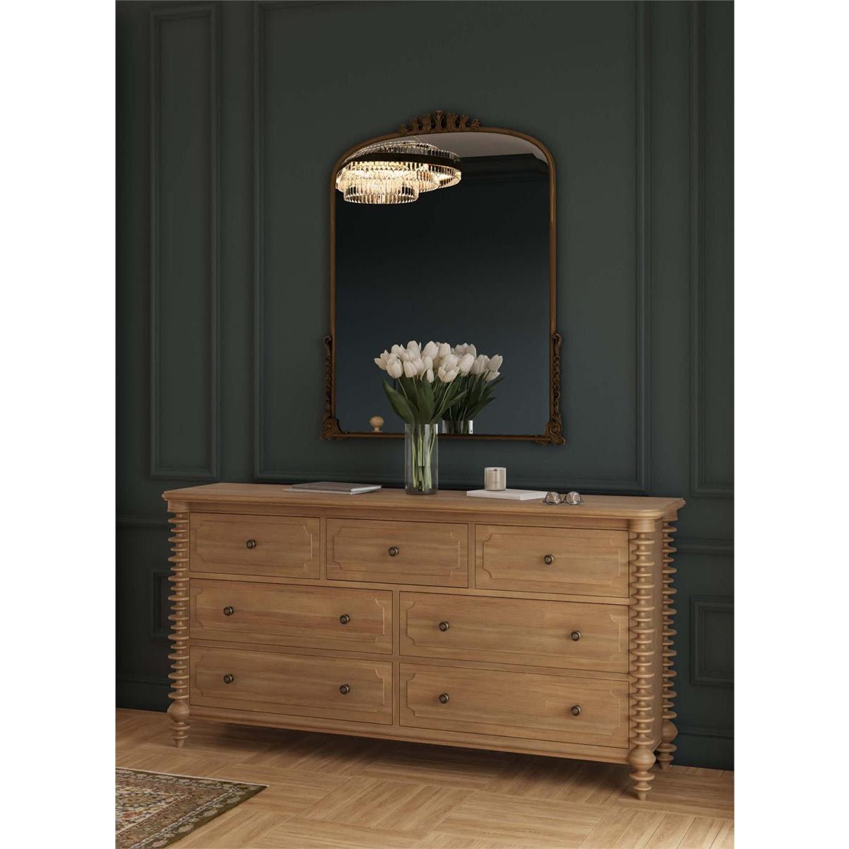 Dresser in elegant room with mirror and flowers.