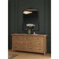 Dresser in elegant room with mirror and flowers.