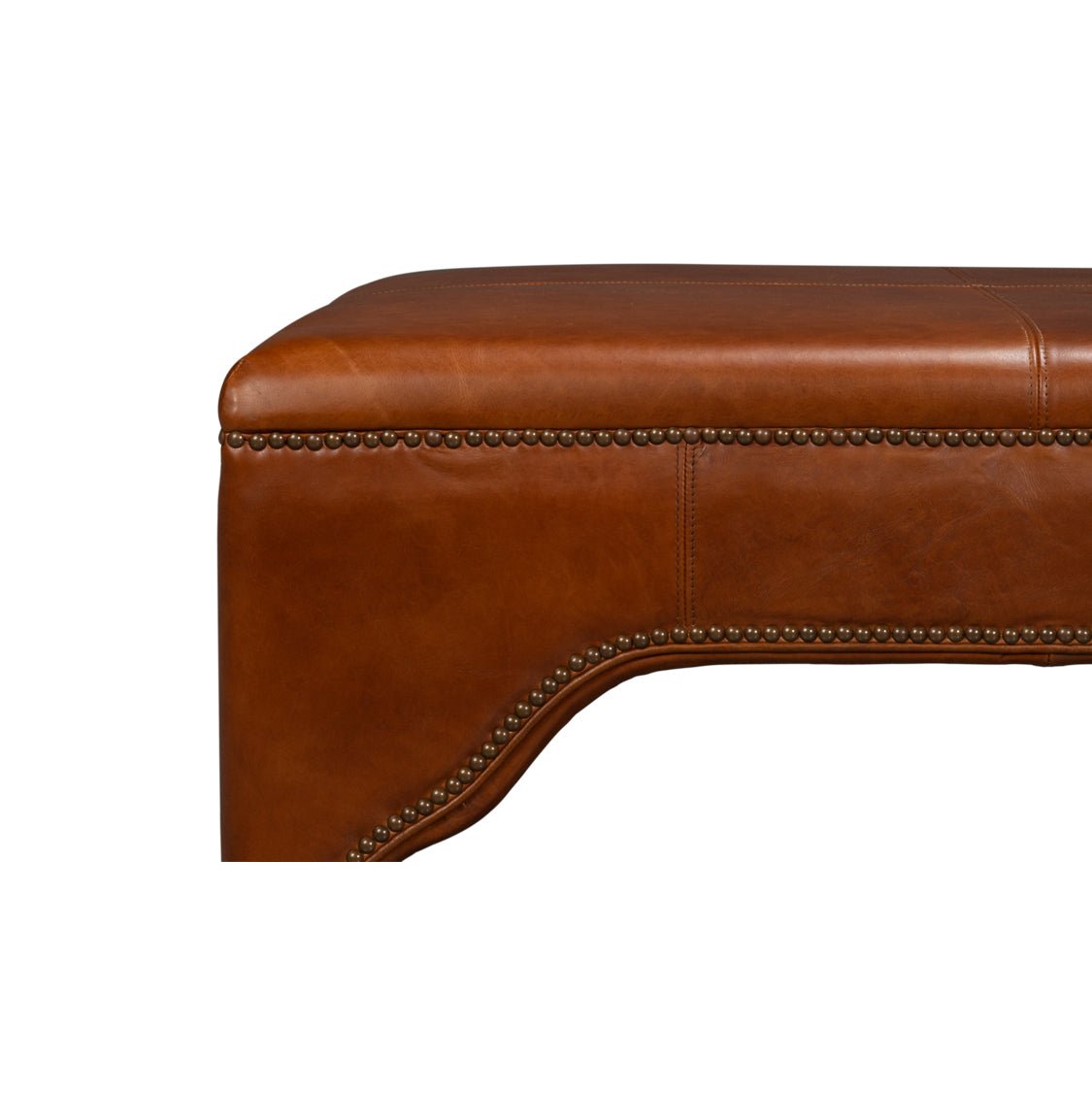 Side detail of brown leather ottoman with nailhead trim.