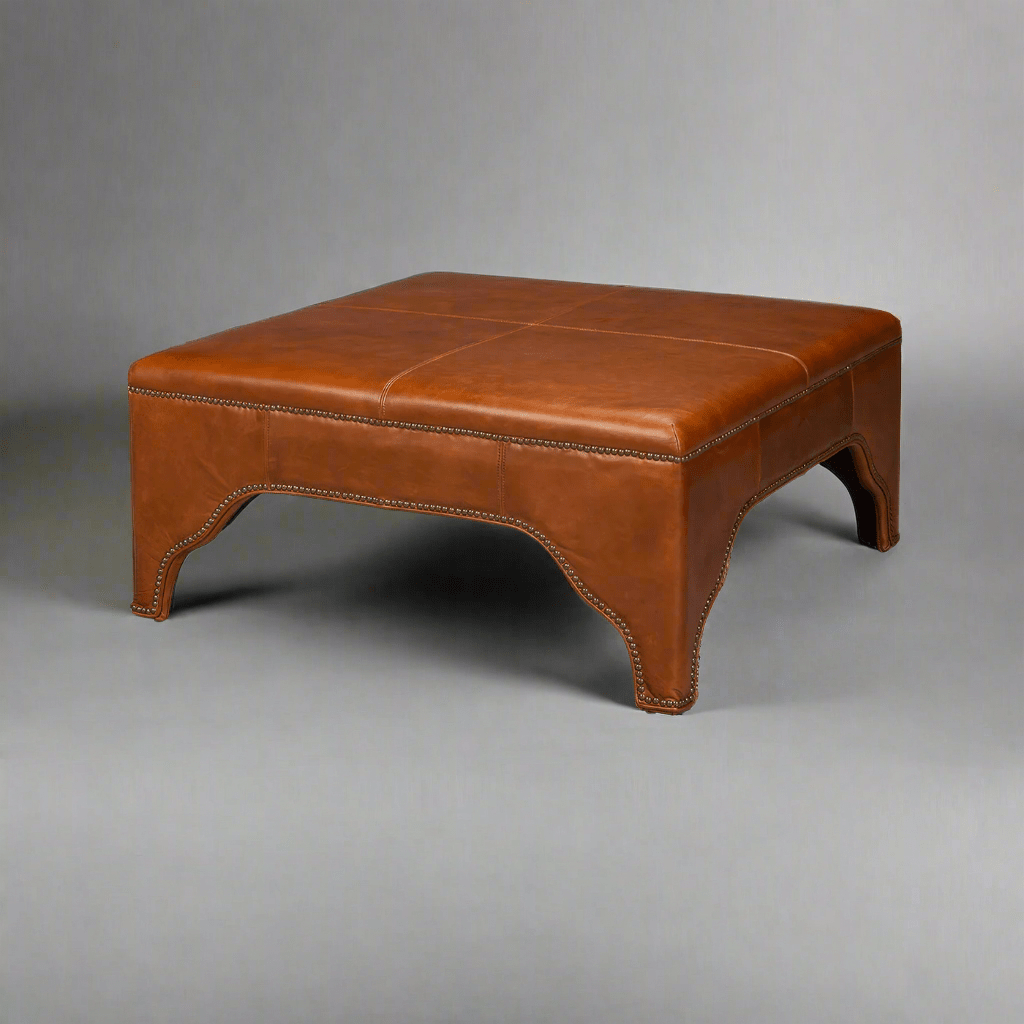 Square brown leather ottoman, plain background, angled view.