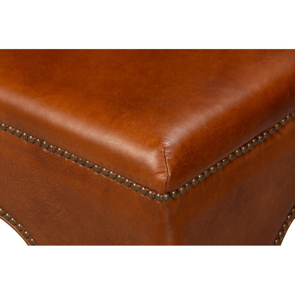 Corner stitching detail on square brown leather ottoman.