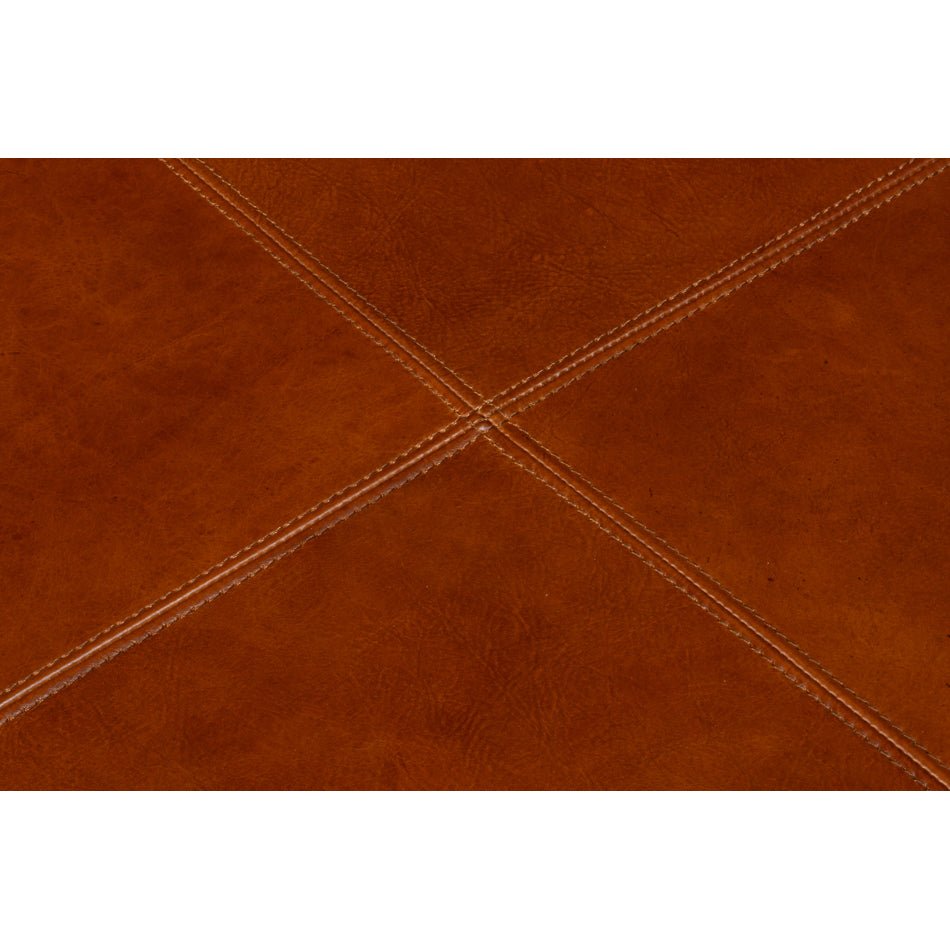 Detailed top stitching on brown leather ottoman.