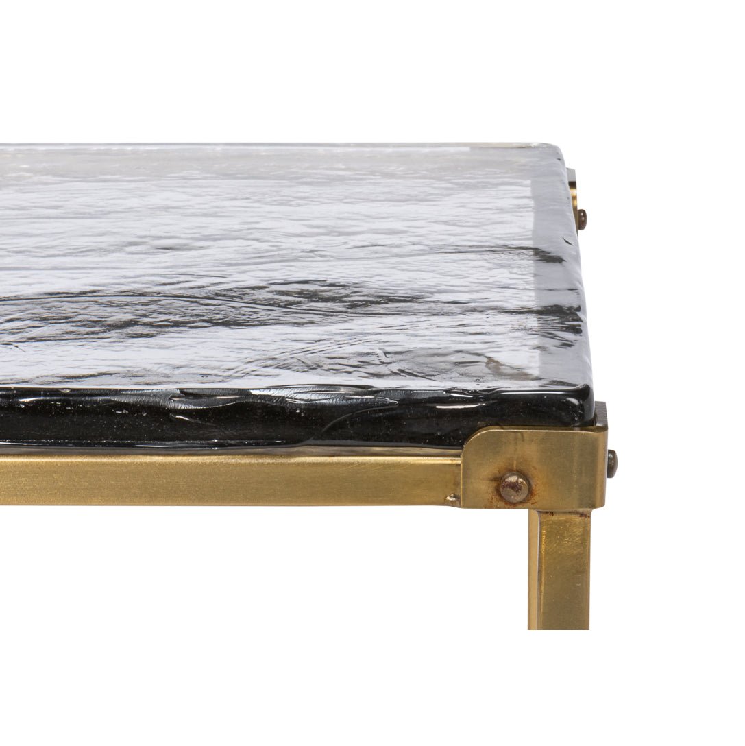 Close-up on glass tabletop corner and brass frame