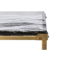 Close-up on glass tabletop corner and brass frame