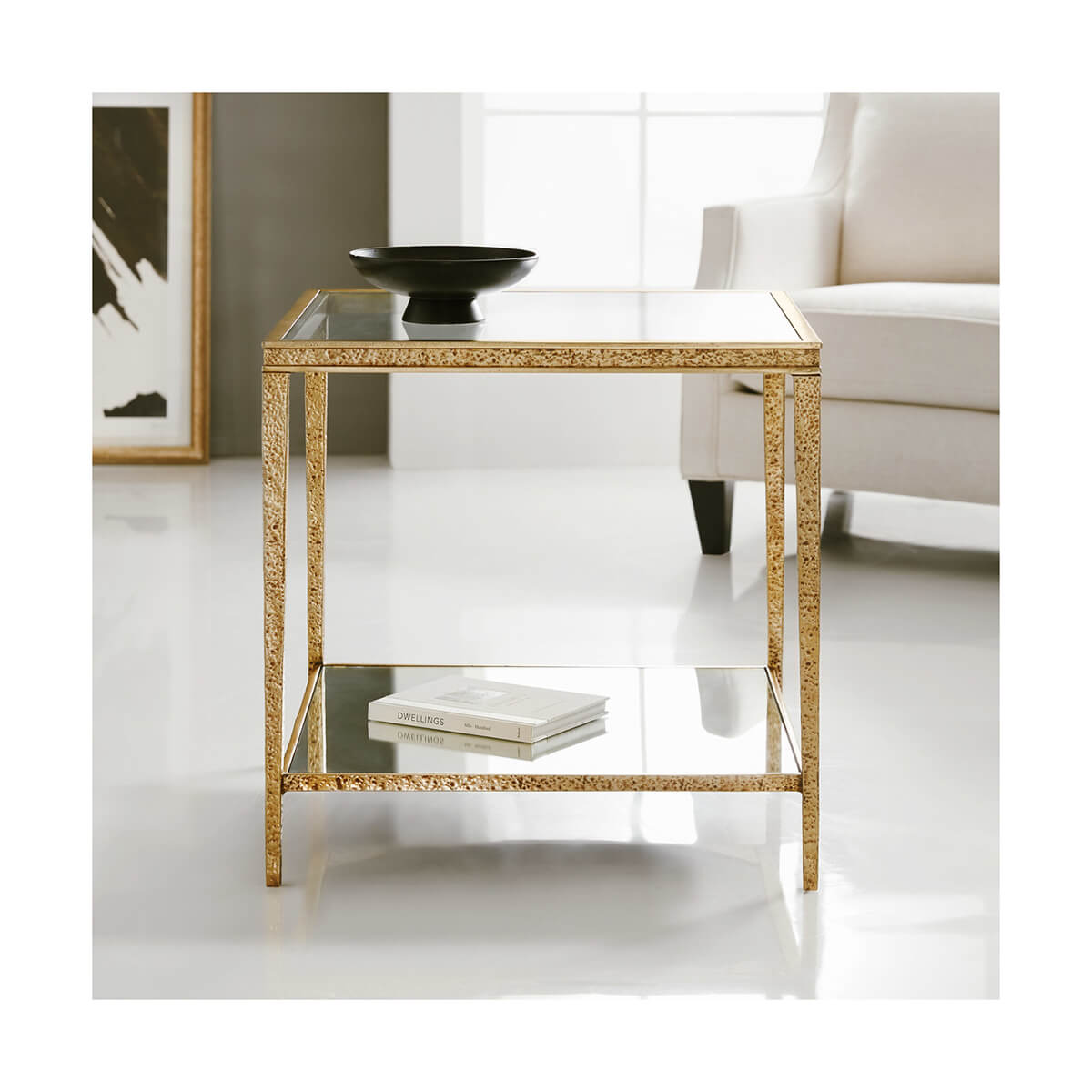 Gold end table styled in living room with decor.
